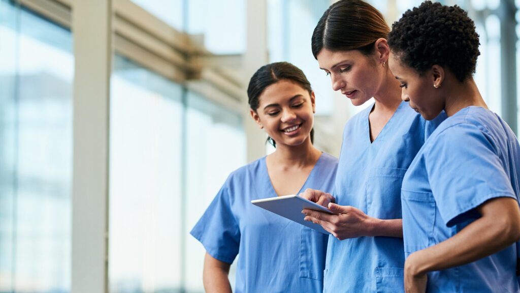 Three healthcare workers looking at patient chart